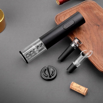 sacacorchos eléctrico negro con accesorios y corcho sobre superficie gris y madera